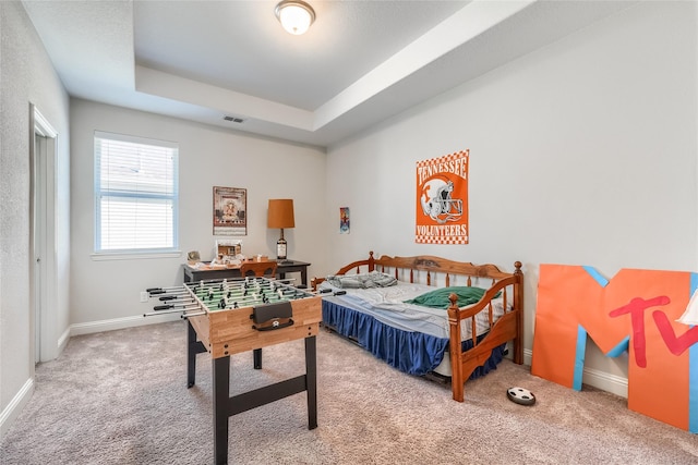 bedroom with carpet flooring and a tray ceiling