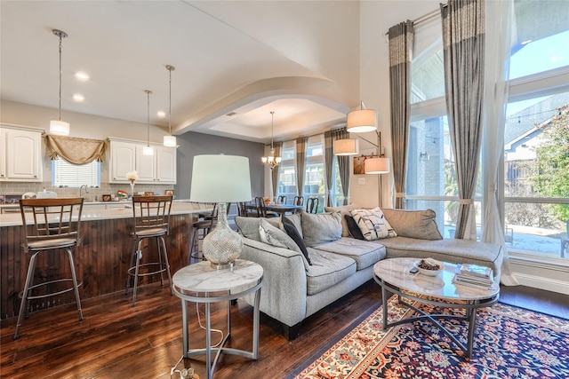 living room with dark wood-type flooring, a notable chandelier, and sink