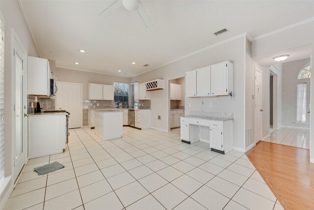 unfurnished living room featuring a fireplace, light hardwood / wood-style floors, crown molding, and ceiling fan