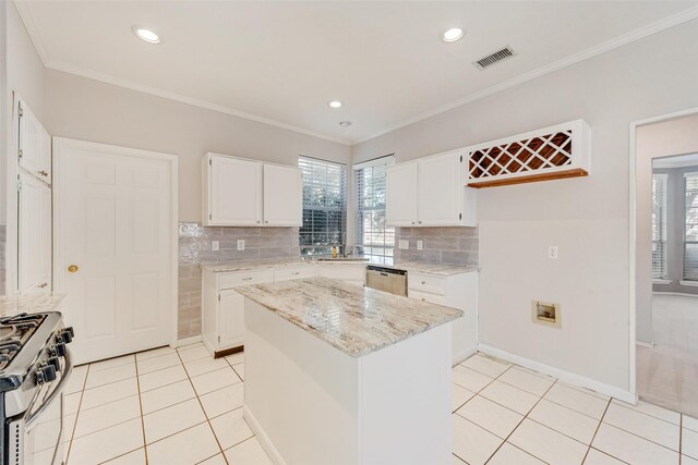 kitchen with white cabinetry, light stone countertops, backsplash, light tile patterned flooring, and range