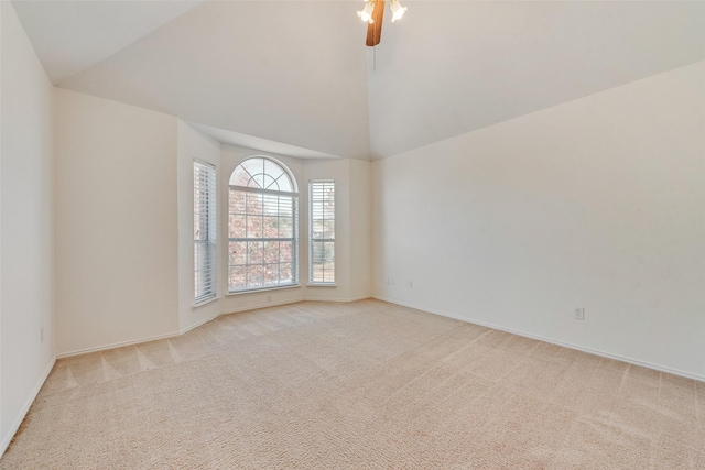 carpeted empty room with high vaulted ceiling and ceiling fan