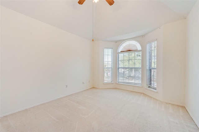 spare room with vaulted ceiling, light carpet, and ceiling fan