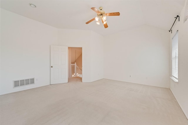 carpeted empty room with vaulted ceiling and ceiling fan