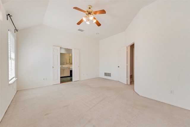 spare room featuring lofted ceiling, light colored carpet, and ceiling fan