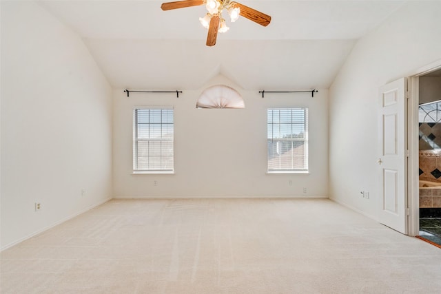 carpeted empty room featuring a tile fireplace, ceiling fan, a healthy amount of sunlight, and lofted ceiling