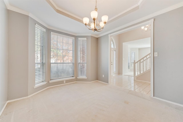 spare room featuring a tray ceiling, crown molding, light carpet, and an inviting chandelier