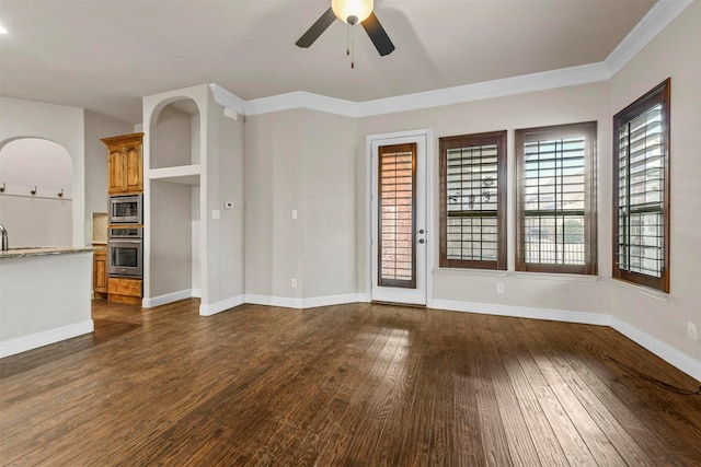 unfurnished living room with sink, crown molding, dark hardwood / wood-style floors, and ceiling fan