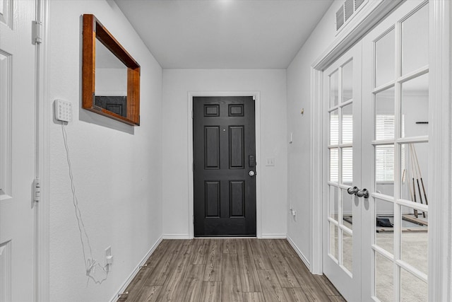 foyer entrance featuring light hardwood / wood-style floors and french doors