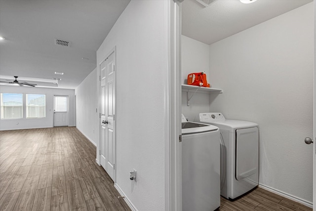 laundry area featuring dark hardwood / wood-style flooring, ceiling fan, and washing machine and clothes dryer