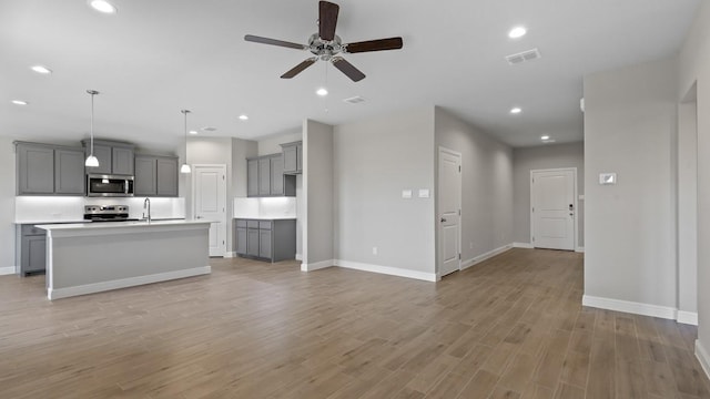 unfurnished living room with ceiling fan and light wood-type flooring