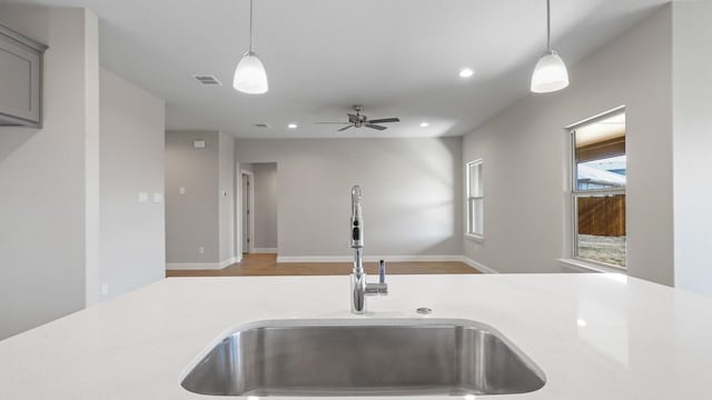 kitchen with sink, pendant lighting, ceiling fan, and gray cabinetry