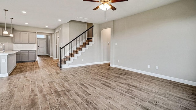 unfurnished living room featuring hardwood / wood-style floors and ceiling fan