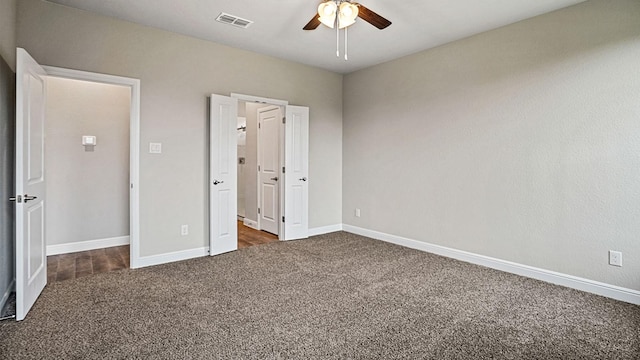 unfurnished bedroom with ceiling fan and dark carpet