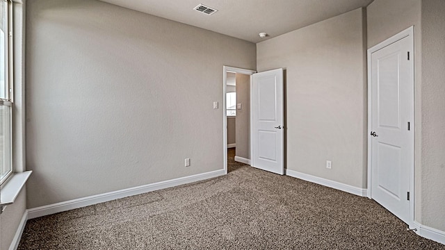 unfurnished bedroom with dark carpet