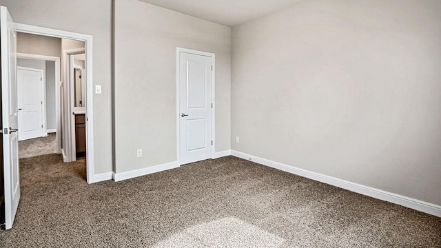 unfurnished bedroom with dark colored carpet