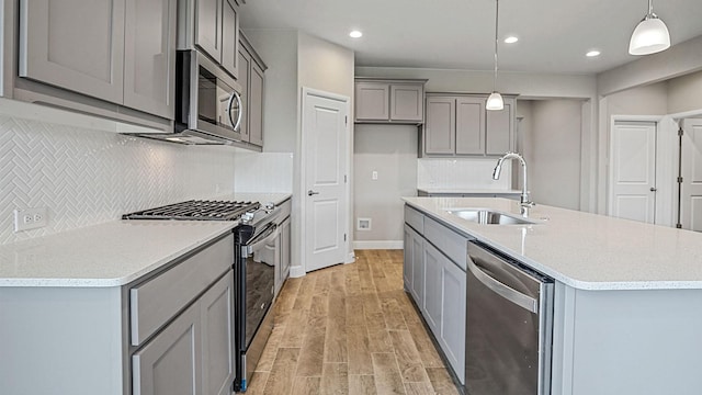 kitchen featuring tasteful backsplash, sink, hanging light fixtures, and appliances with stainless steel finishes