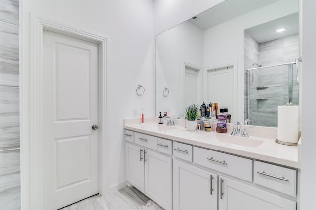 bathroom with vanity and a shower with door