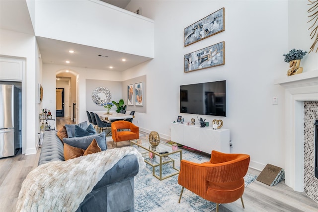 living room featuring light hardwood / wood-style flooring and a towering ceiling