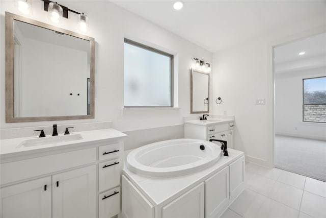 bathroom with tile patterned floors, vanity, and a bath