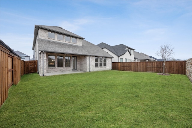 rear view of property featuring a yard and a patio area