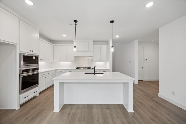 kitchen featuring white cabinetry, appliances with stainless steel finishes, sink, and hanging light fixtures