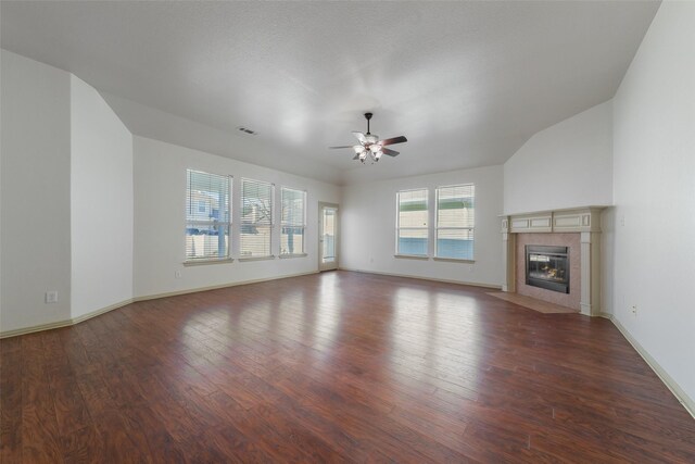 unfurnished living room featuring ceiling fan, a fireplace, vaulted ceiling, and hardwood / wood-style flooring