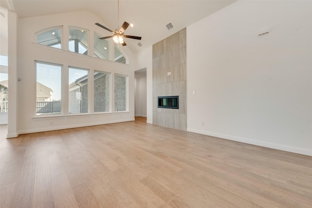 3542 Coneflower Trl, Prairie Ridge, TX 76084 - unfurnished living room featuring light wood-type flooring, ceiling fan, high vaulted ceiling, a fireplace, and baseboards