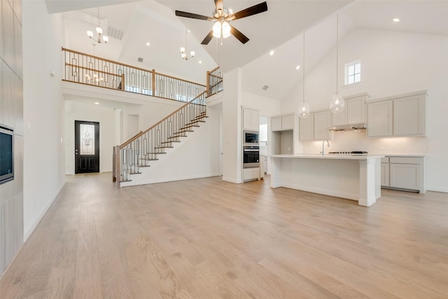 3542 Coneflower Trl, Prairie Ridge, TX 76084 - unfurnished living room with high vaulted ceiling, ceiling fan, light wood finished floors, a sink, and stairs