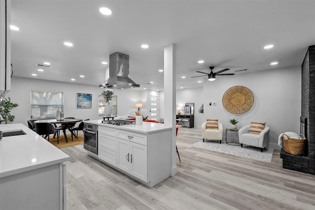 kitchen featuring white cabinetry, extractor fan, stainless steel appliances, and light hardwood / wood-style floors