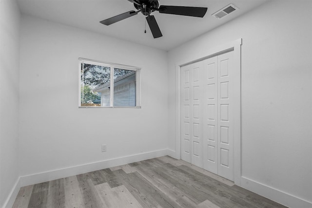 unfurnished bedroom featuring ceiling fan, light hardwood / wood-style flooring, and a closet