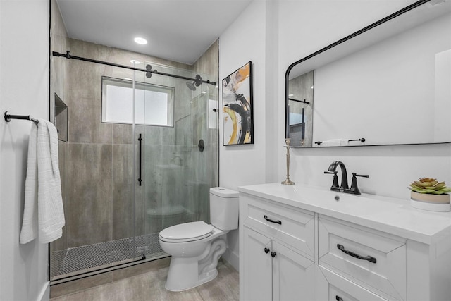 bathroom featuring vanity, hardwood / wood-style flooring, toilet, and a shower with door