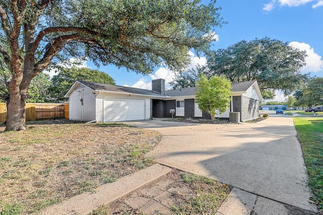 ranch-style house featuring a garage and central AC