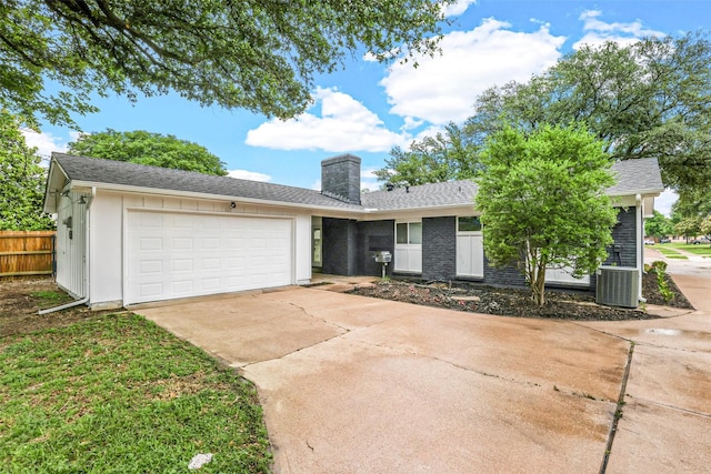 ranch-style home featuring a garage and central AC