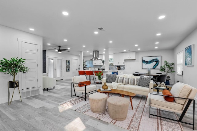 living room with light hardwood / wood-style floors and ceiling fan