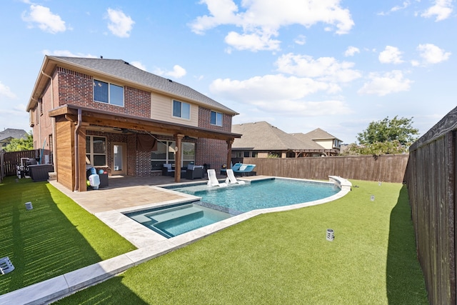 rear view of property with outdoor lounge area, ceiling fan, a swimming pool with hot tub, a patio, and a lawn