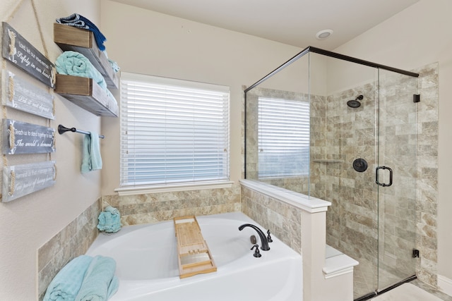 bathroom featuring shower with separate bathtub