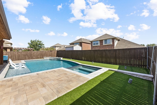 view of swimming pool featuring a lawn, a patio area, pool water feature, and an in ground hot tub