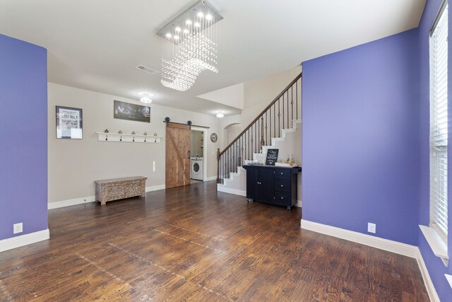 interior space with a notable chandelier, washer / dryer, dark wood-type flooring, and a barn door