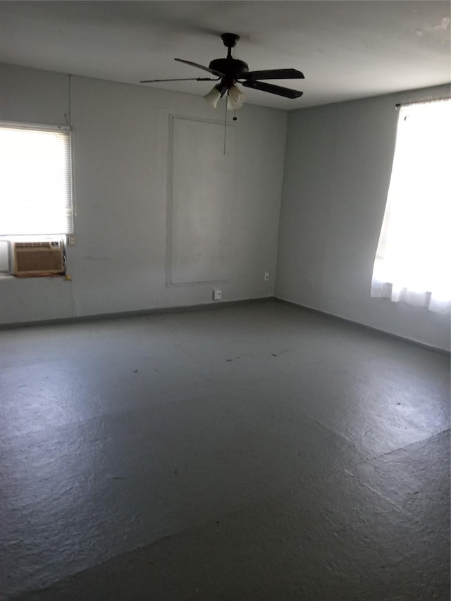 spare room featuring cooling unit, a wealth of natural light, concrete flooring, and ceiling fan