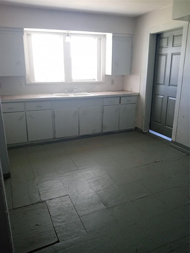 kitchen featuring sink and white cabinets