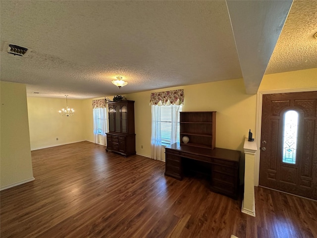 entrance foyer with an inviting chandelier, dark hardwood / wood-style floors, and a textured ceiling