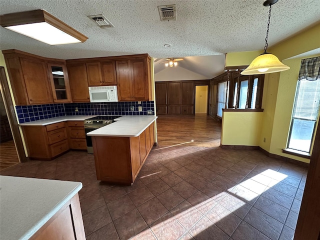 kitchen with stainless steel electric range oven, hanging light fixtures, a textured ceiling, a kitchen island, and decorative backsplash