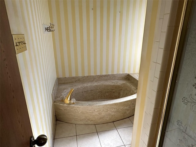 bathroom with a washtub and tile patterned floors