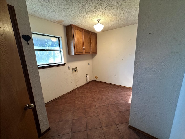 laundry room with cabinets, hookup for an electric dryer, hookup for a washing machine, and a textured ceiling