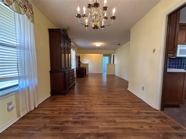 interior space featuring dark hardwood / wood-style floors, a chandelier, and a textured ceiling