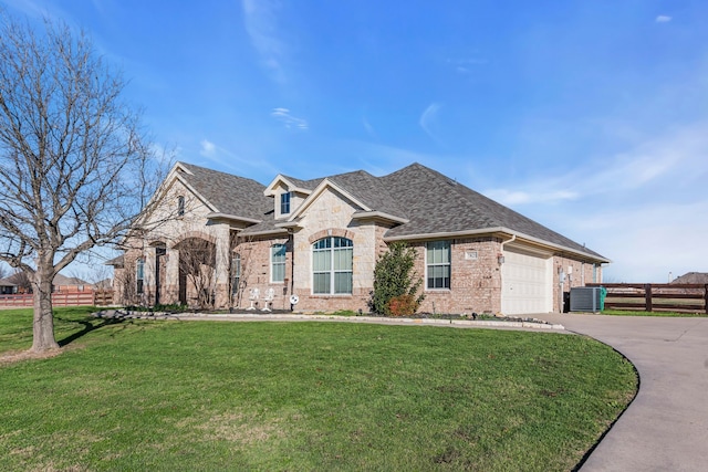 view of front of property featuring central AC, a garage, and a front lawn