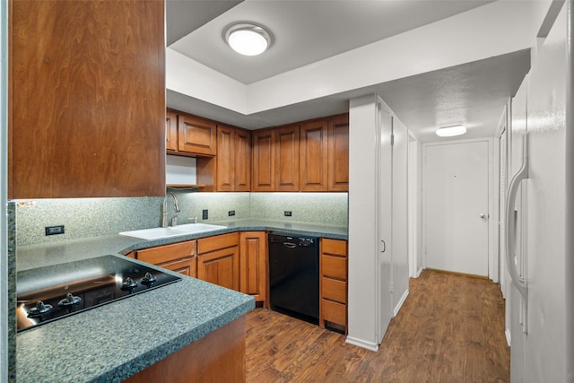 kitchen with hardwood / wood-style flooring, sink, tasteful backsplash, and black appliances