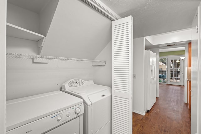 washroom with separate washer and dryer, dark wood-type flooring, and a textured ceiling