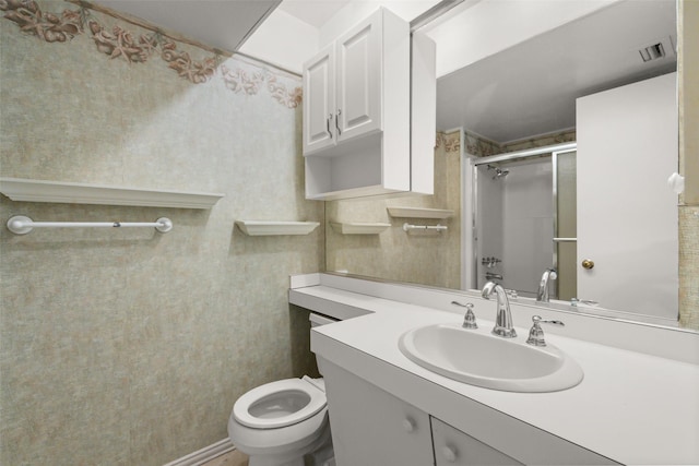 bathroom with vanity, toilet, and an enclosed shower