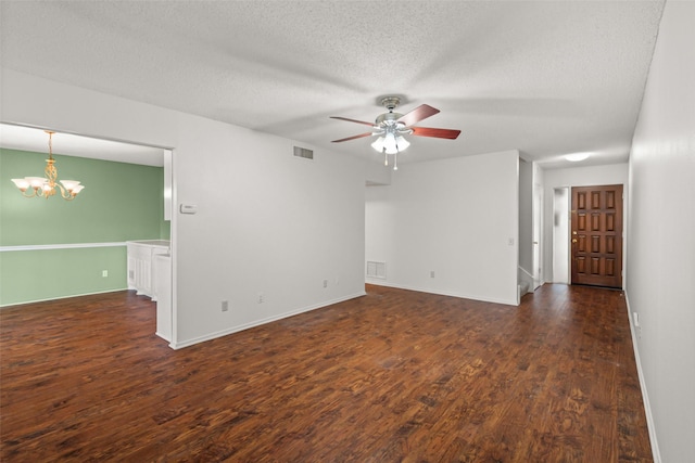 empty room with dark hardwood / wood-style floors, ceiling fan with notable chandelier, and a textured ceiling